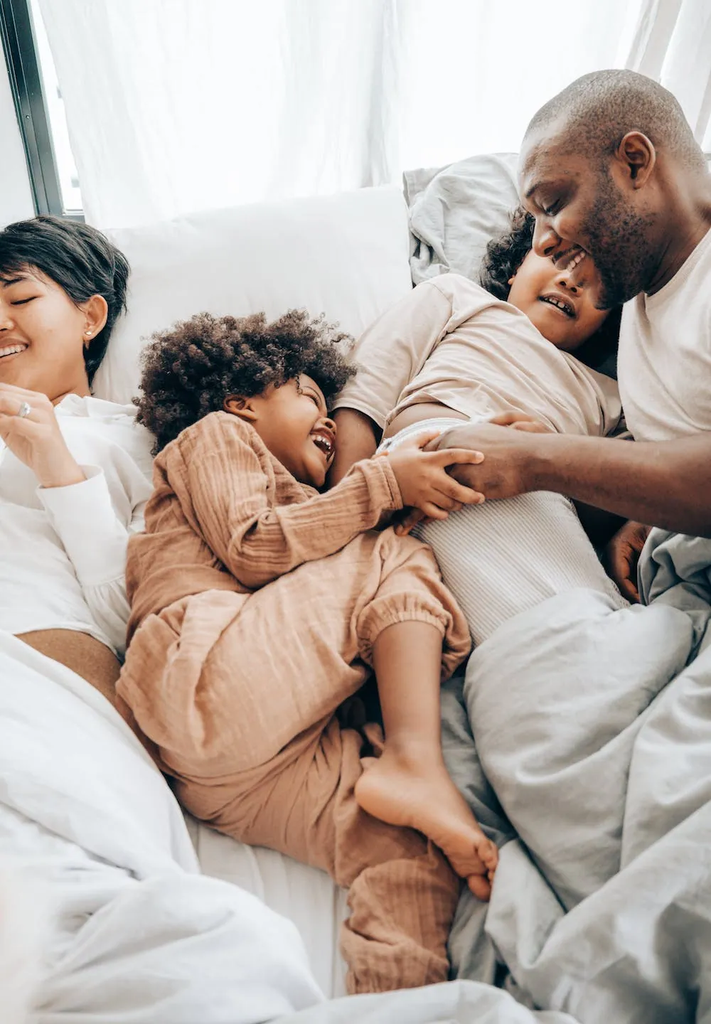 laughing kids in bed with mom and dad